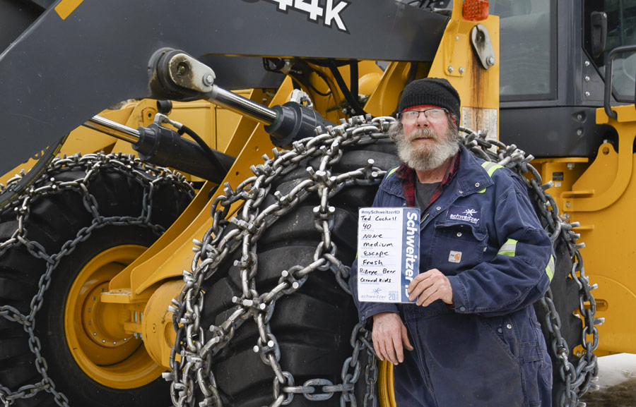Ted standing infront of a loader with his SchweitzerID card